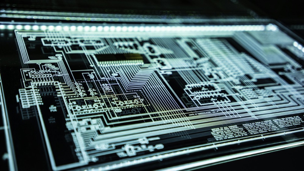 A dense lattice of luminous circuit traces on a dark surface, evoking structured data